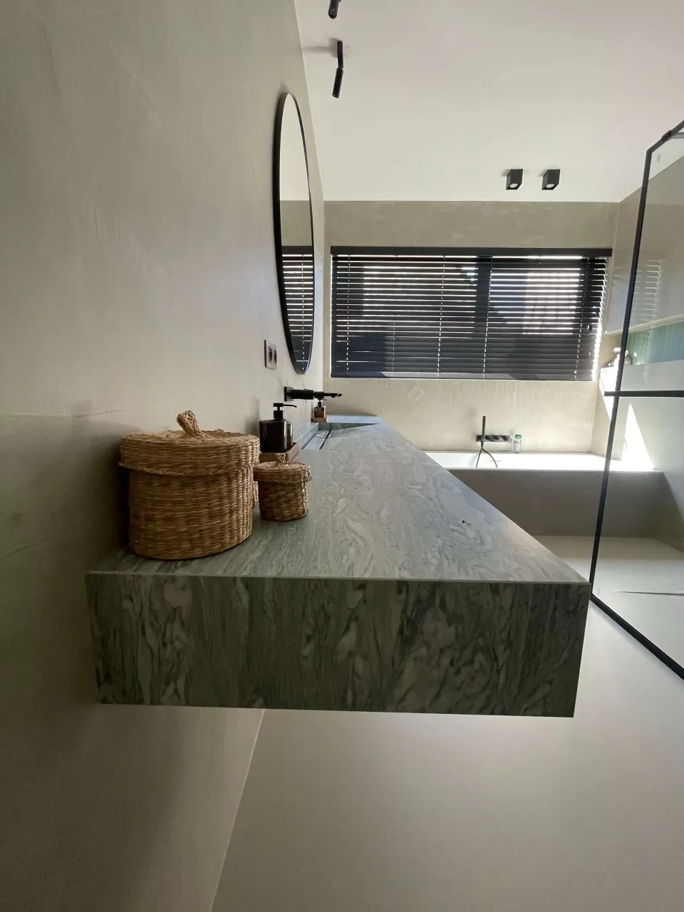 Wastafel in marmerlook tegen mortex wand